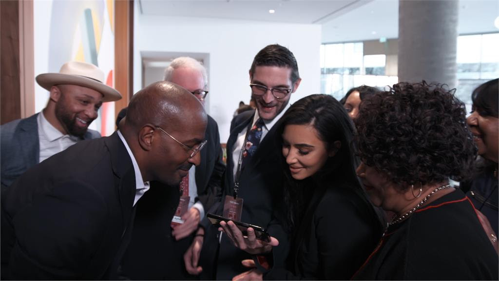 Van Jones, Kim Kardashian, Alice Johnson, Louis L. Reed and Alex Guditch of #cut50 huddle over a cell phone to watch president Trump deliver a speech on the First Step Act in a scene from THE FIRST STEP.